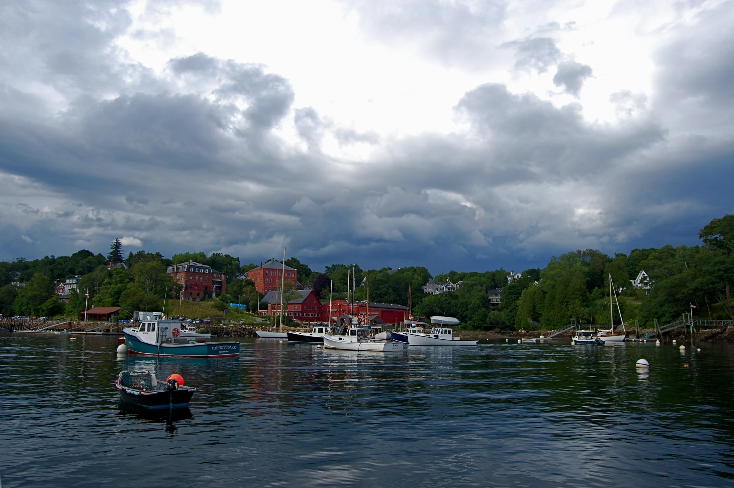 boats are sitting in the water under cloudy skies