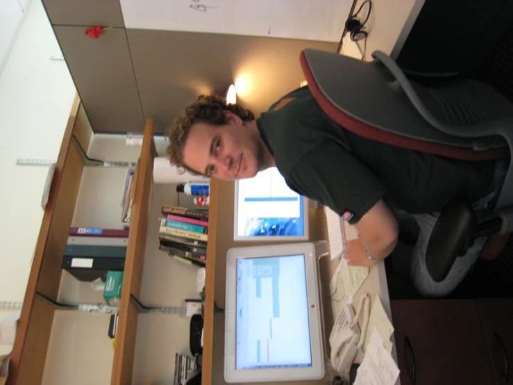 a man sits in front of his desk and works on the computer