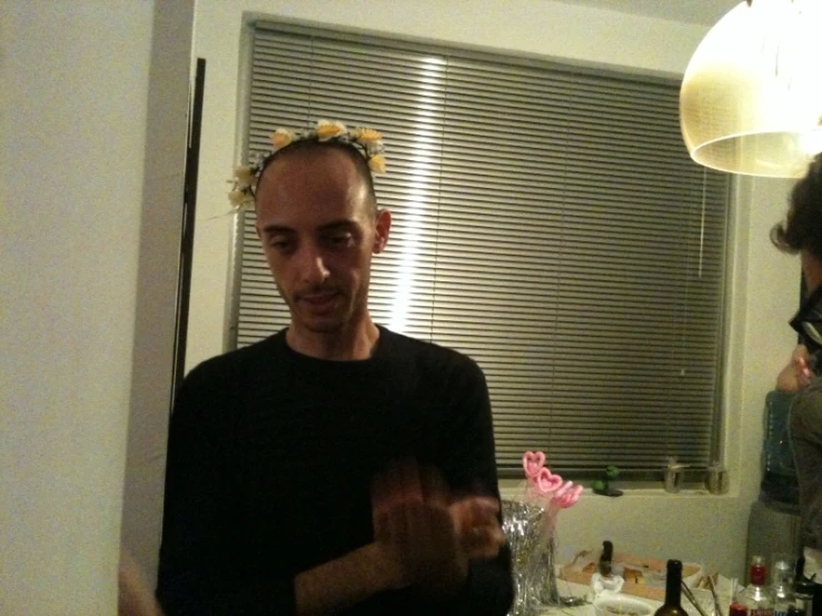 a man is standing in a kitchen making a hand gesture