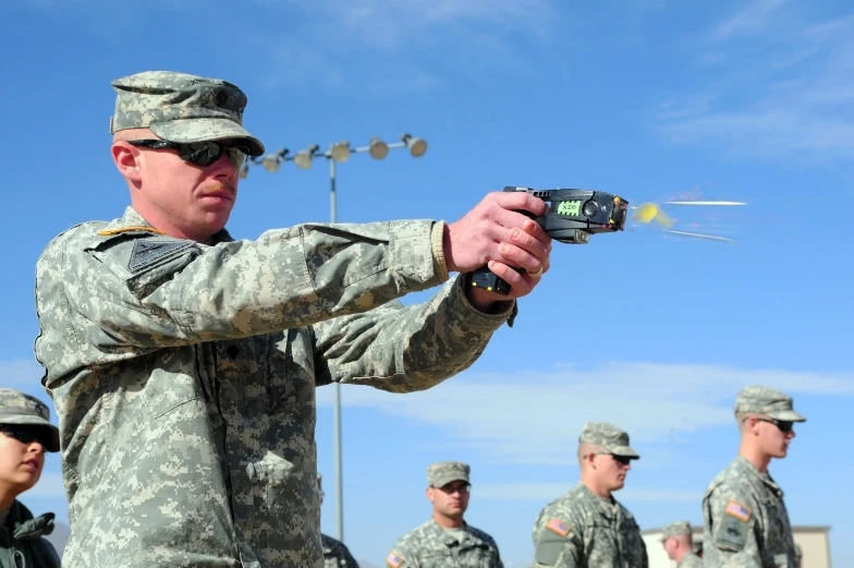 two men in uniform hold their guns up to the camera