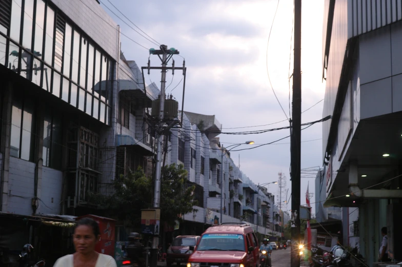 traffic on a city street at dusk with buildings and cars