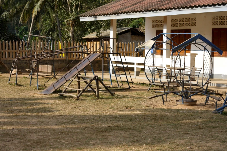 a row of swings next to a wooden house