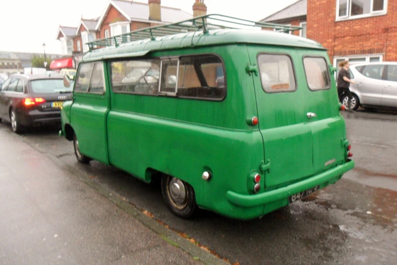 a green van with a metal roof sitting on the side of the road