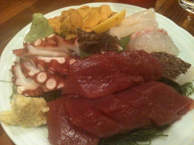 some types of raw fish are on a plate