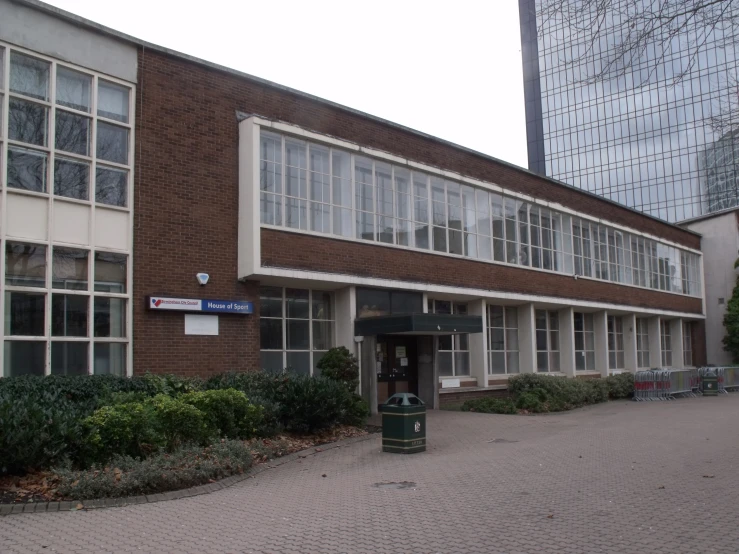 a building with an open door, a tree and green plants