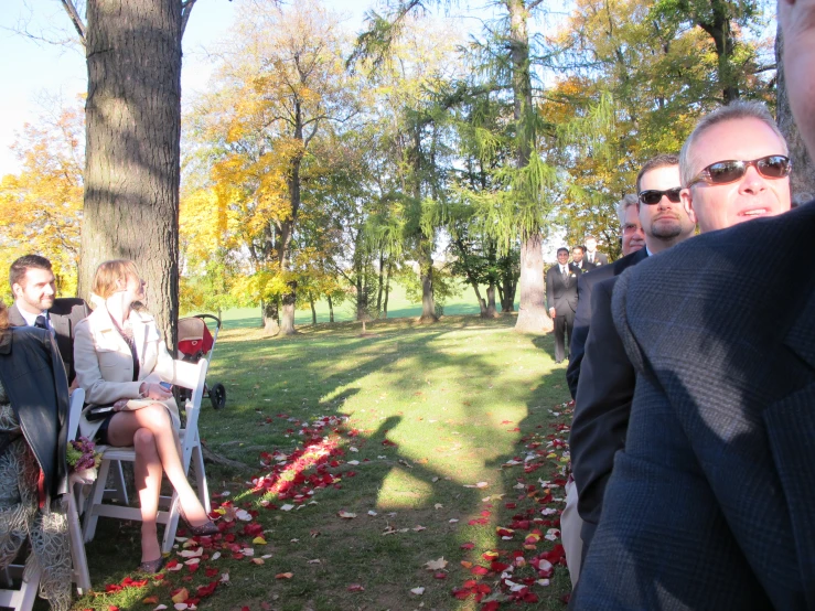 a man and woman are sitting on chairs next to an area filled with flowers