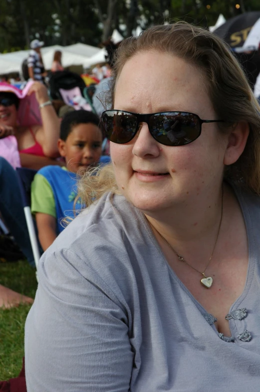 the woman is wearing glasses and is resting on her side