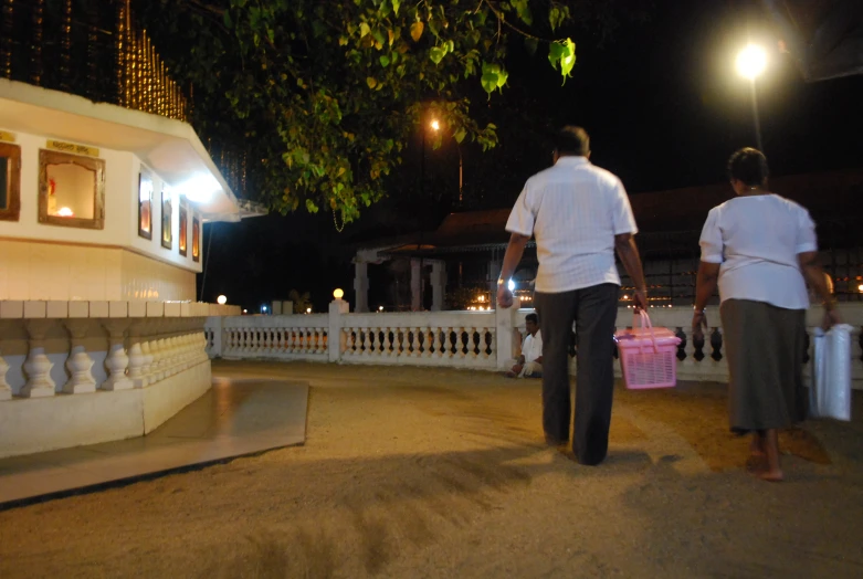 two people are walking through the streets at night