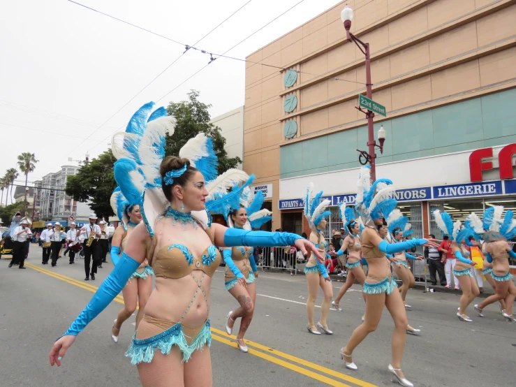 a number of women in bikinis marching down a street