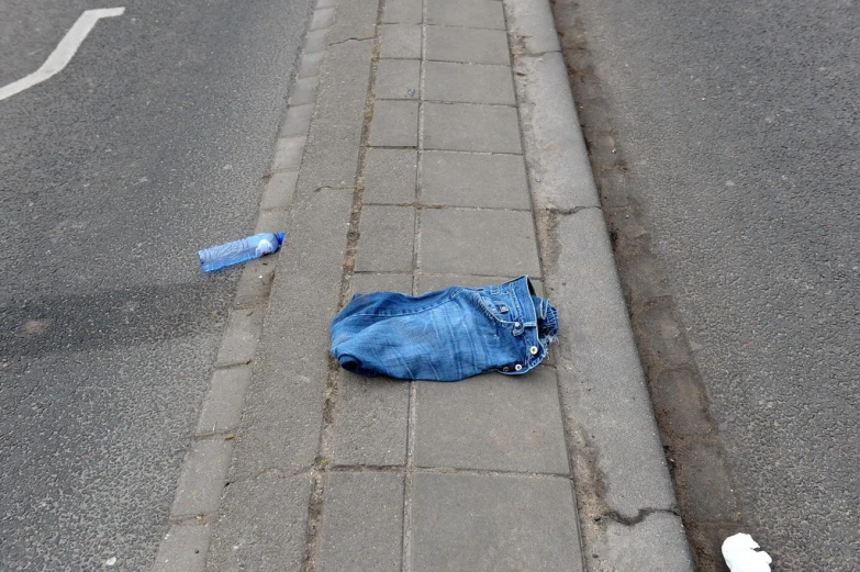 an open denim shirt lies on a brick walk