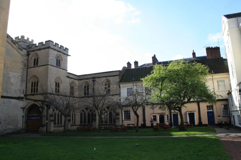 an old building in front of a large grass field