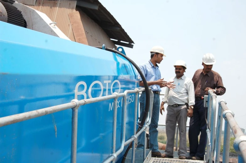 three men are standing on a track next to a train