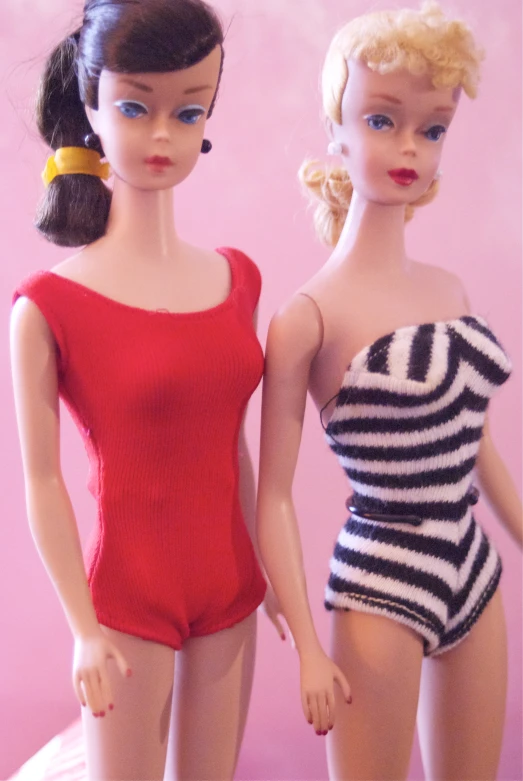 two doll dressed in bathing suits, one with a ponytail