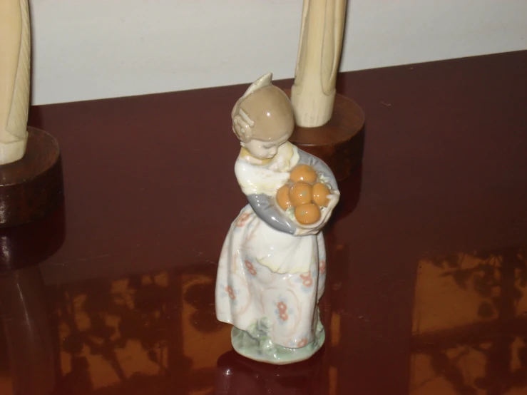 a small figurine holding a plate of cookies sitting on a table