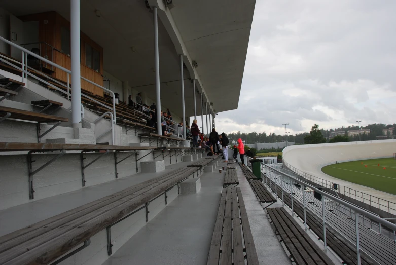 people standing in a stadium on a rainy day