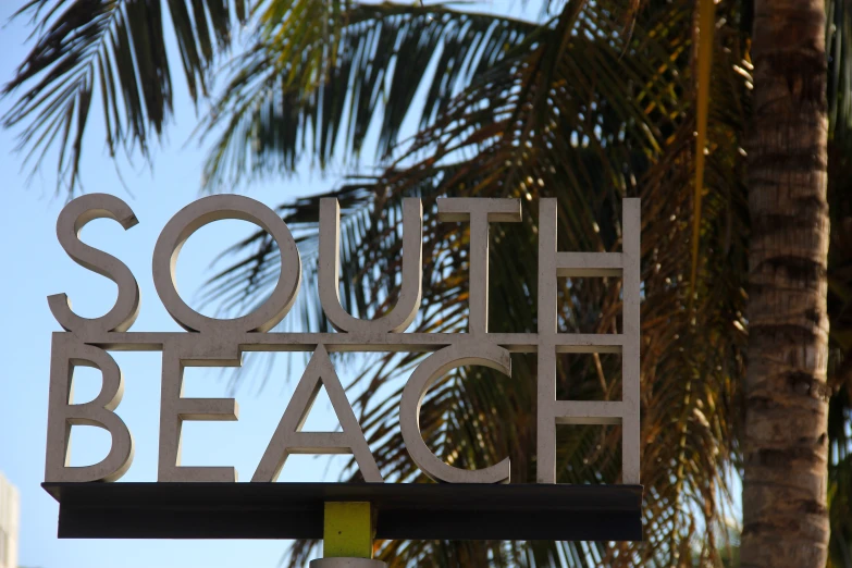 a sign that reads south beach in front of trees