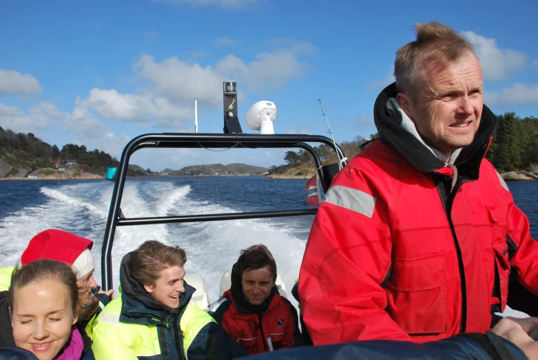 a man standing on the side of a boat holding soing in his hand