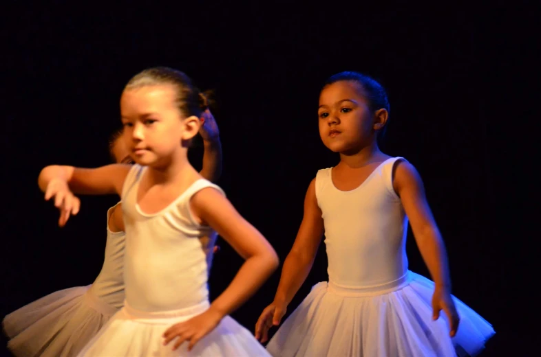 two little girls in white and tulle skirts standing