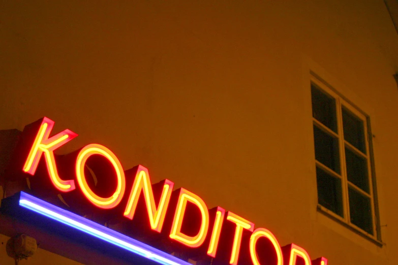 a neon sign for kondist next to a building