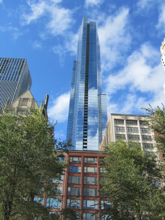 a high rise building in new york city, seen through the trees