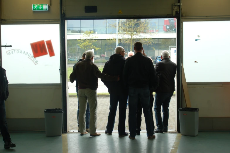 a group of people are waiting outside the building for their turn