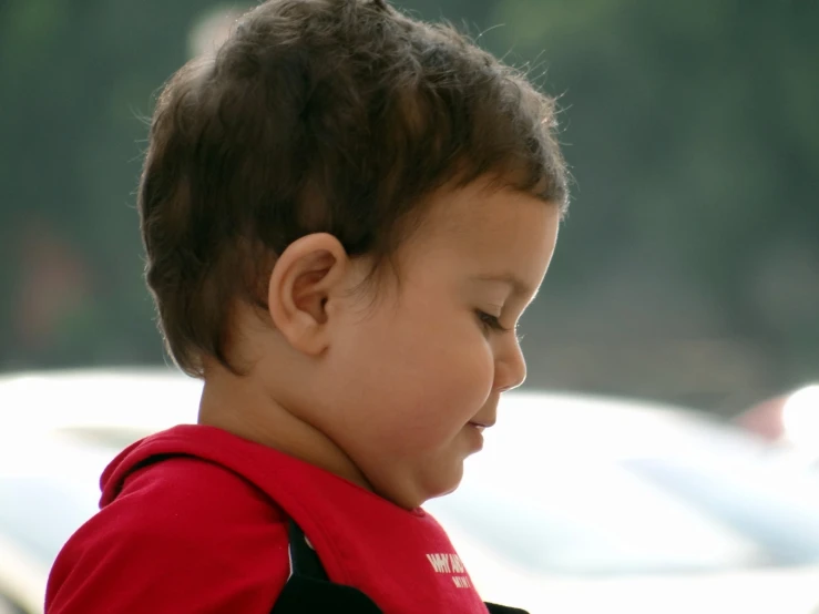 a little boy that has some kind of cellphone in hand