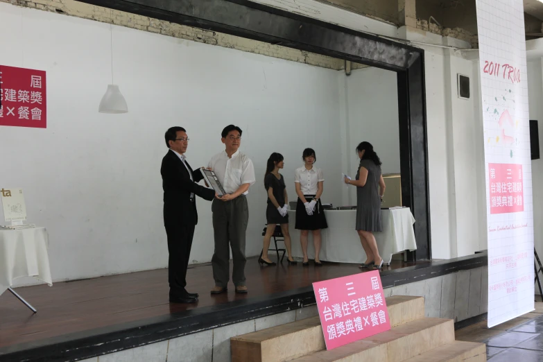 a group of people shaking hands in front of a white wall