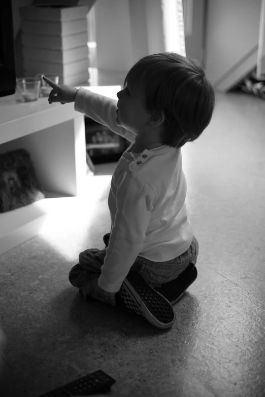 a baby sitting in front of a tv on the floor