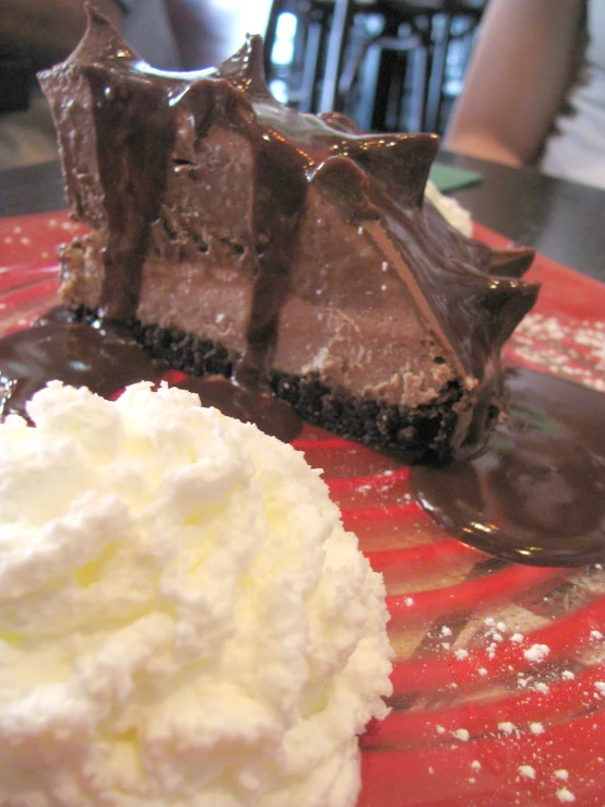 a piece of cheesecake and scoop of ice cream sitting on top of a table