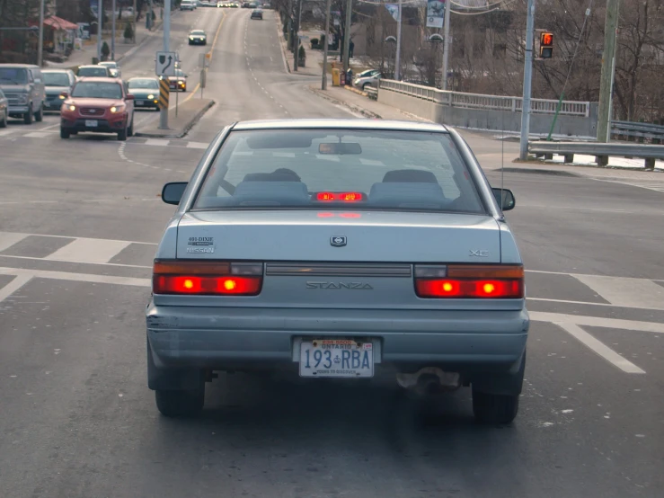 a silver car at an intersection waiting for the light to change