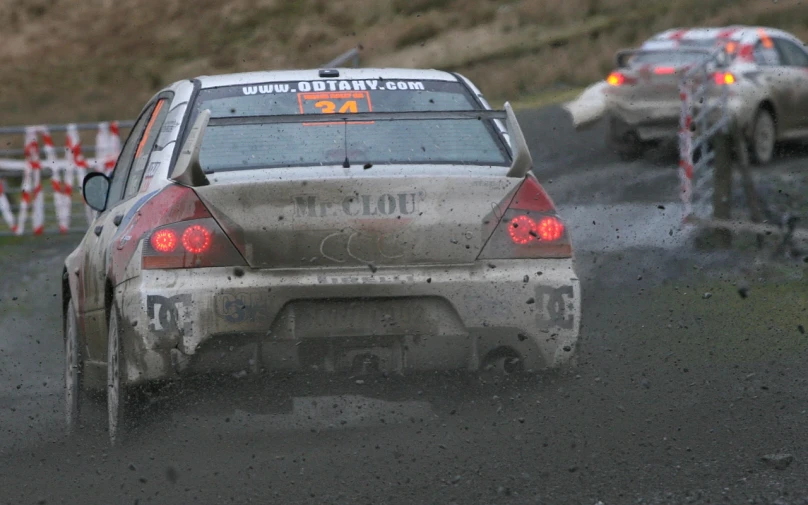 two vehicles driving on dirt road during a race