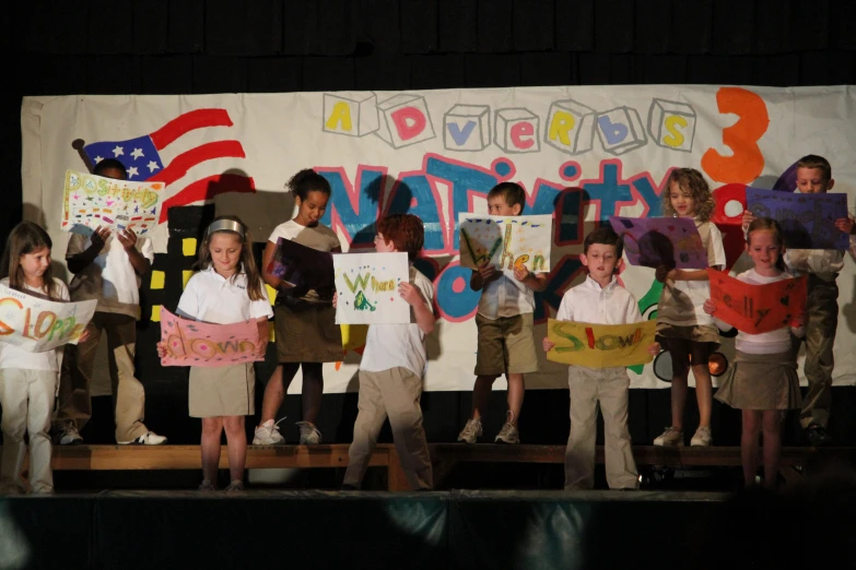 children in school uniforms sing and sing on stage