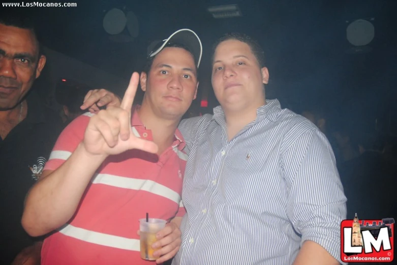 two guys posing for a po together at a nightclub