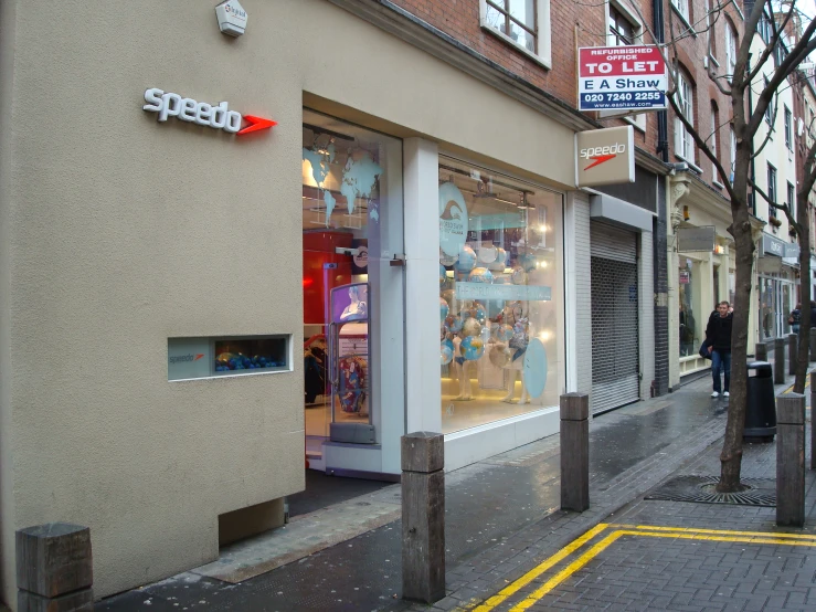 a storefront with a sign on the corner next to it