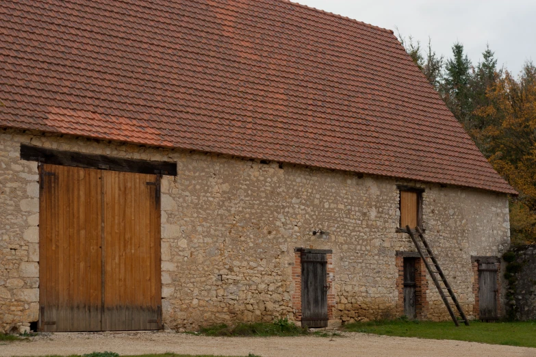 an old brick building has two large wooden doors