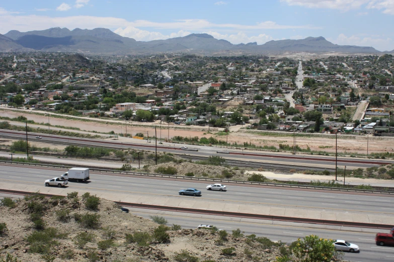 some cars on a highway with mountains in the background