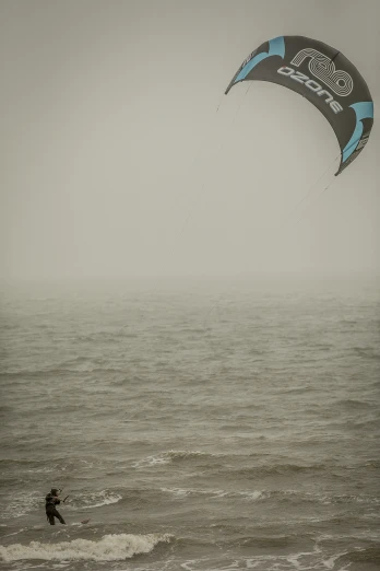 a person standing in the surf with a parasail