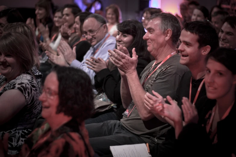 several people sitting in a crowd and one standing up