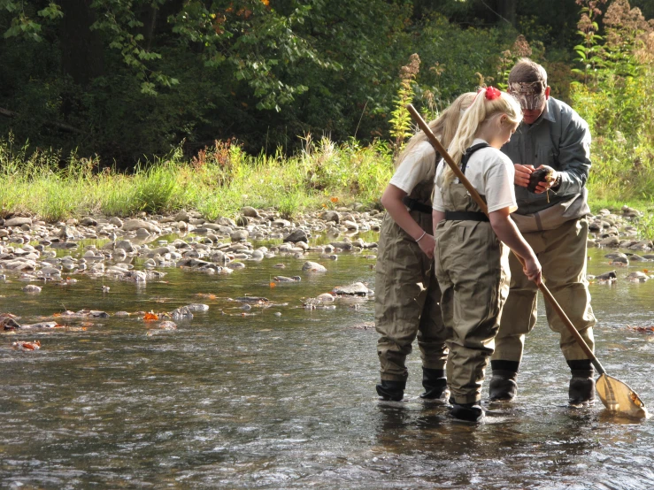 two men are standing in the river with their backs turned to the water