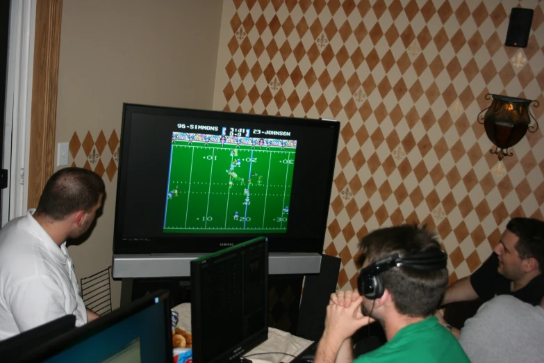 two men wearing headset are watching a video game