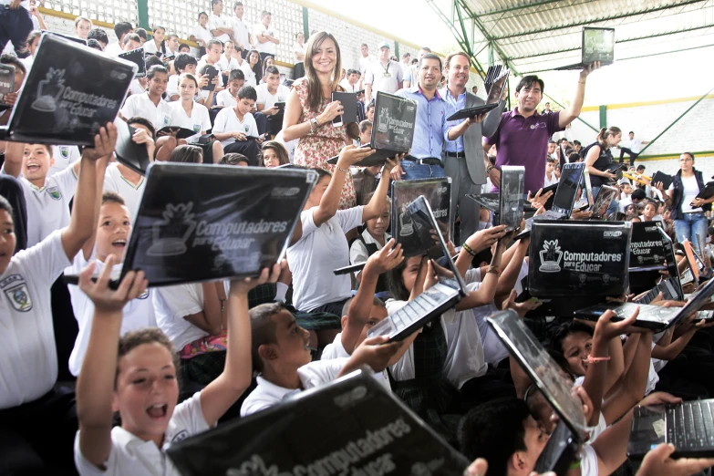 many people hold up their ipads in front of an audience