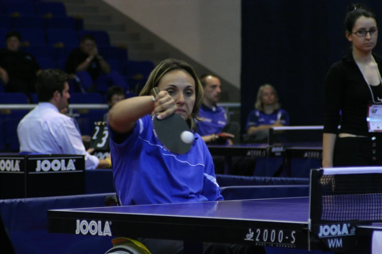 a girl playing ping pong in an indoor court