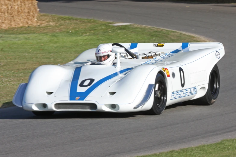 an older style car is going down the track