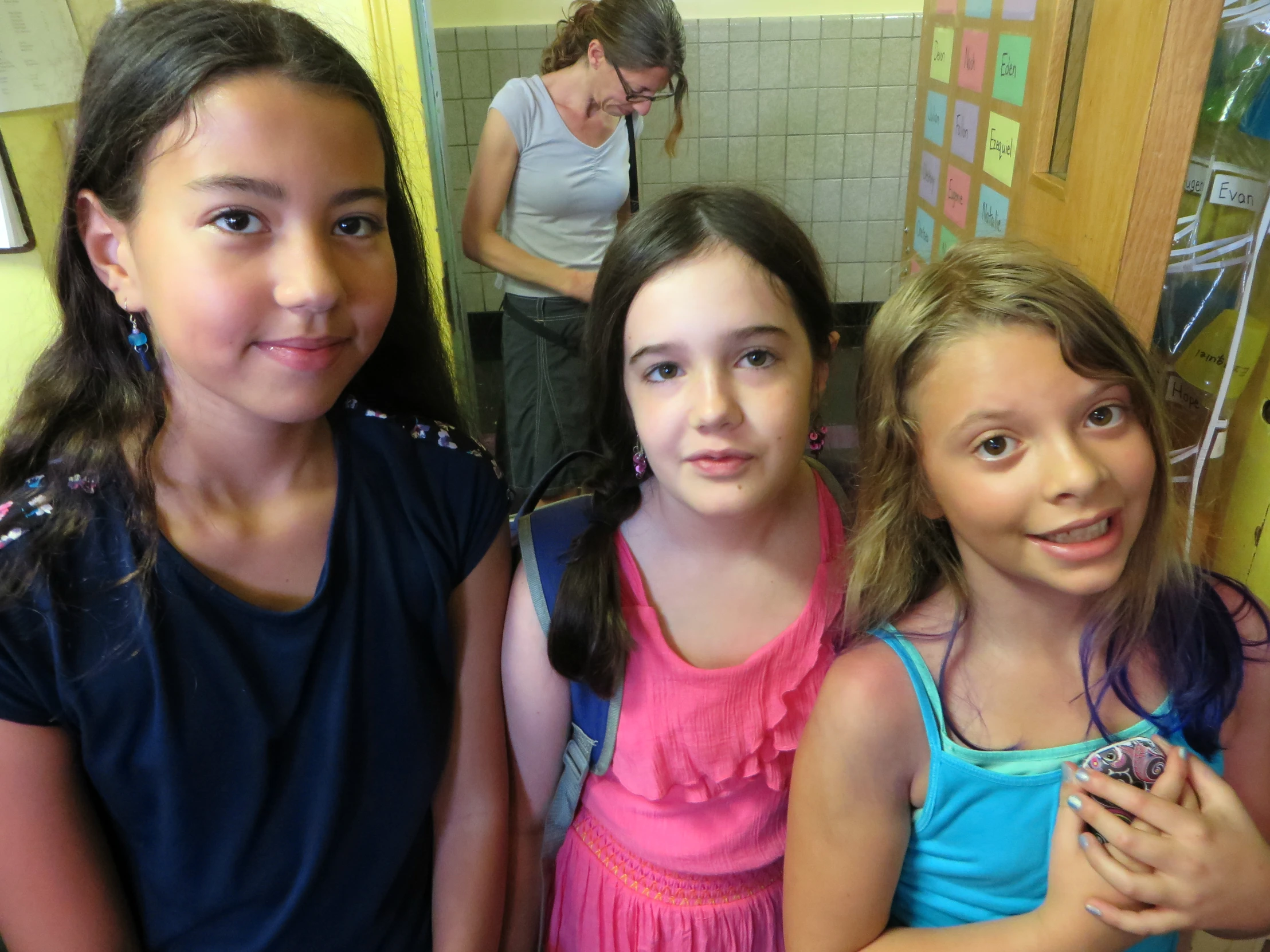 three little girls standing together in a bathroom