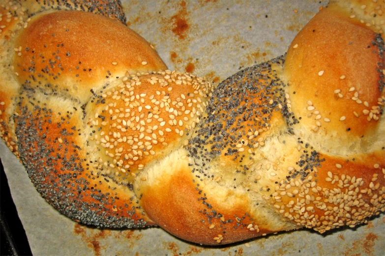 several rolls are sprinkled with poppy seed and cheese