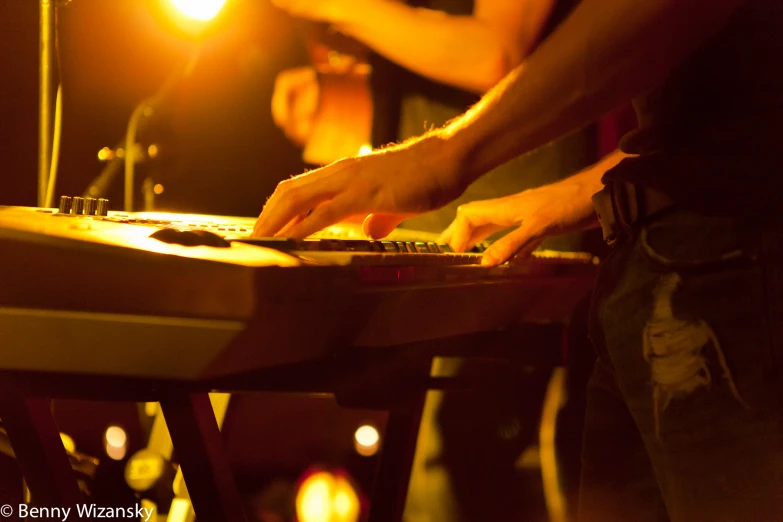 a man is playing the piano while someone sits nearby