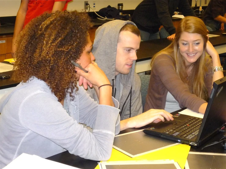 a group of people with long hair on computers