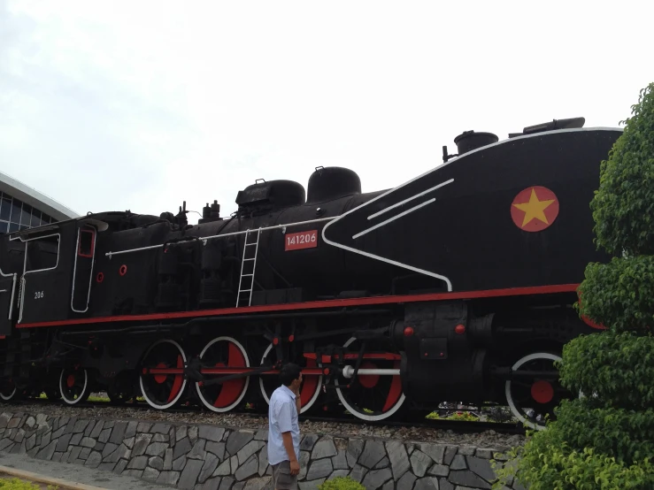 a man in front of an old locomotive train