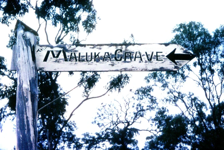 a white sign with black letters hanging from a pole