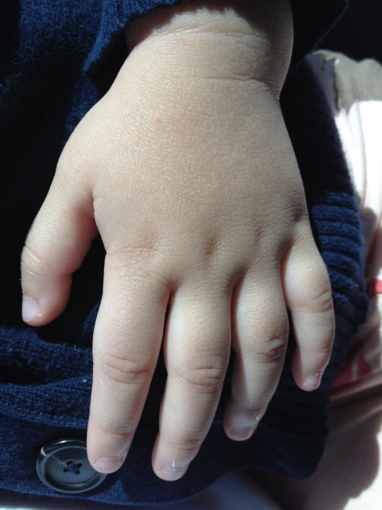 a small infant hand touching the ground